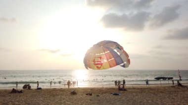 13 Mart 2020, KARON BEACH, PHUKET, THAILAND: Güneşli bir günde kıyıya parasolar kurulmuş, güneşli bir günde güneşlenen ve suda yüzen sayısız turistin bulunduğu tropik plaj.