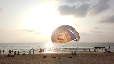 13 Mart 2020, KARON BEACH, PHUKET, THAILAND: Güneşli bir günde kıyıya parasolar kurulmuş, güneşli bir günde güneşlenen ve suda yüzen sayısız turistin bulunduğu tropik plaj.