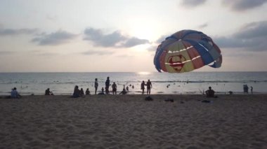 13 Mart 2020, KARON BEACH, PHUKET, THAILAND: Güneşli bir günde kıyıya parasolar kurulmuş, güneşli bir günde güneşlenen ve suda yüzen sayısız turistin bulunduğu tropik plaj.