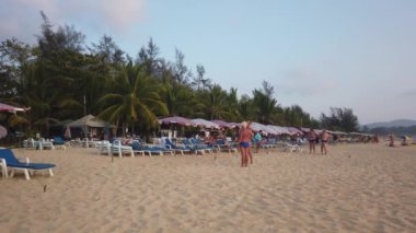 13 Mart 2020, KARON BEACH, PHUKET, THAILAND: Güneşli bir günde güneşin altında güneşlenen ve yüzen sayısız turistin bulunduğu tropik plaj.
