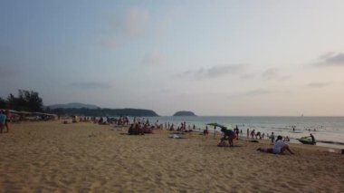 13 Mart 2020, KARON BEACH, PHUKET, THAILAND: Güneşli bir günde güneşin altında güneşlenen ve yüzen sayısız turistin bulunduğu tropik plaj.