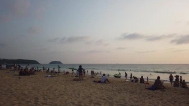 13 Mart 2020, KARON BEACH, PHUKET, THAILAND: Güneşli bir günde güneşin altında güneşlenen ve yüzen sayısız turistin bulunduğu tropik plaj.