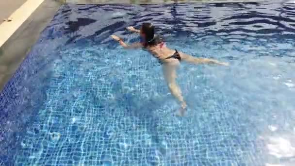 Gadis berambut cokelat berenang di kolam renang di hari yang cerah — Stok Video