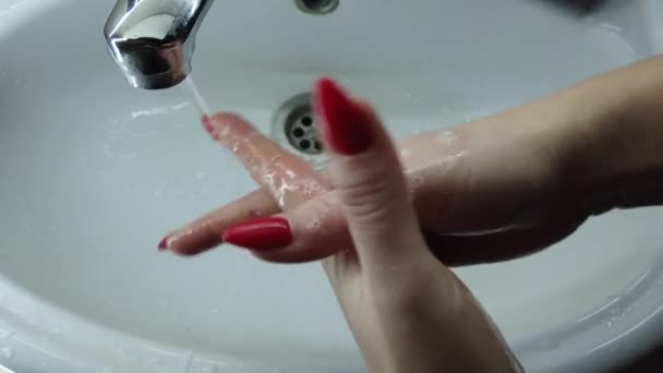 女の子はバスルームで石鹸で手を徹底的に洗う 水道から水が流れています 感染を防ぐ 閉鎖だ コロナウイルスのパンデミック予防温水石鹸で手を洗う — ストック動画