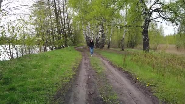 Dziewczyna Spaceruje Wiejską Drogą Pobliżu Lasu — Wideo stockowe