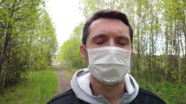 Korumalı tıbbi maskeli bir adam ormanda