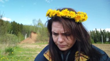 Kafasında karahindiba çelengi olan güzel, gülümseyen esmer kız.