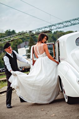 Klasik araba ve şoför elbise tutan girerek gelin