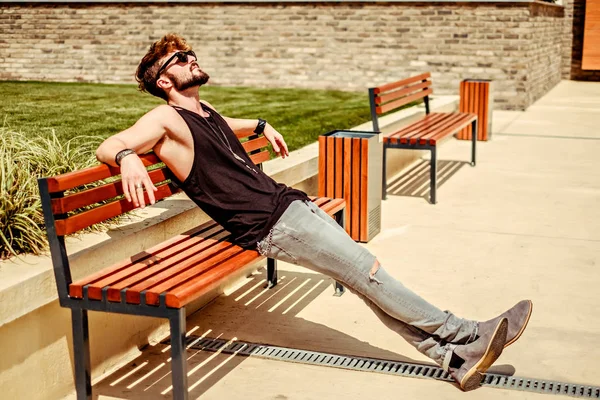 Hipster uomo barbuto pensare e riposare sulla panchina — Foto Stock