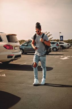 Adam bir park yerinde telefon kullanarak dreadlocks ile