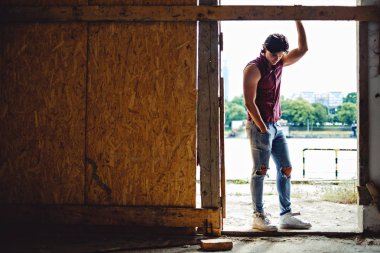 Elini tutarak ve yere bakarak maço adam