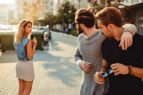 Amigos do sexo masculino olhando para a menina na rua — Fotografia de Stock