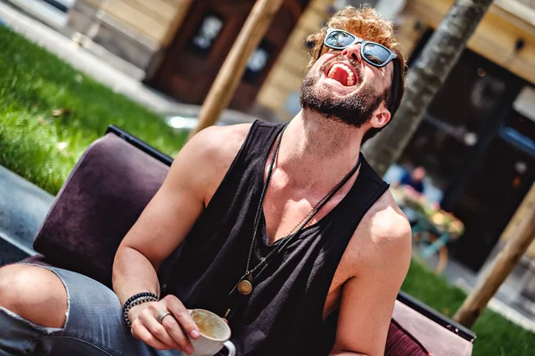 Hipster ride mentre tiene in mano una tazza di caffè — Foto Stock