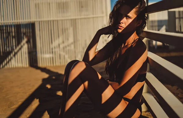Sexy chica sentada en la sombra en la playa —  Fotos de Stock