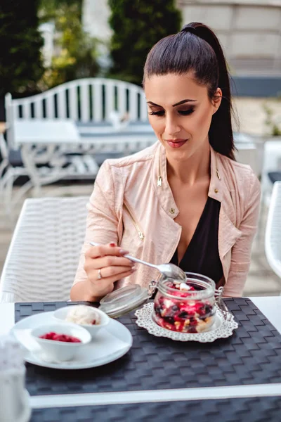 Красивая девушка ест фруктовый ванильный торт в ресторане — стоковое фото