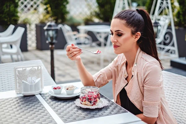 Красивая девушка наслаждается фруктовым ванильным тортом в ресторане — стоковое фото