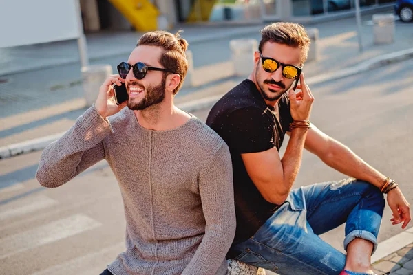 두 친구는 거리에 앉아 전화 통화 — 스톡 사진