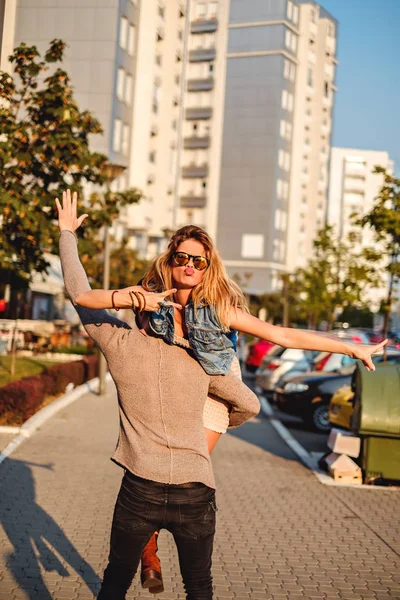 Uomo che trasporta donna mentre lei fa il broncio — Foto Stock