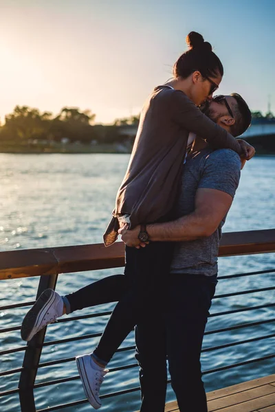 男を持ち上げると夕日で彼のガール フレンドのキス — ストック写真