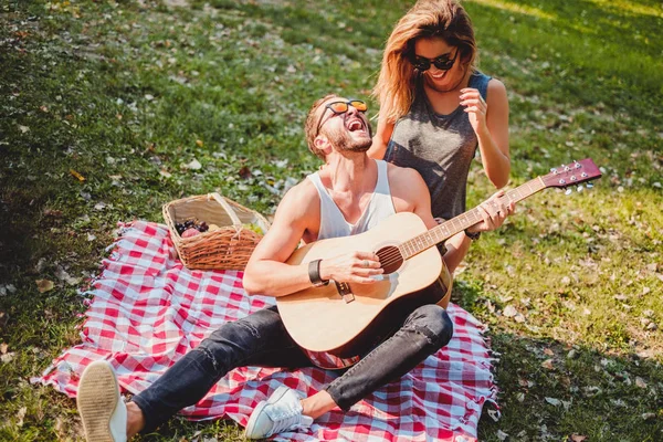 Uomo che canta alla sua ragazza su un picnic — Foto Stock