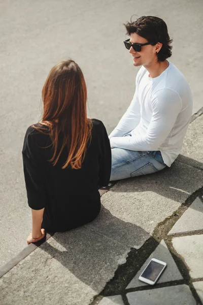 Man flirting with girl while sitting on a wall — Stock Photo, Image