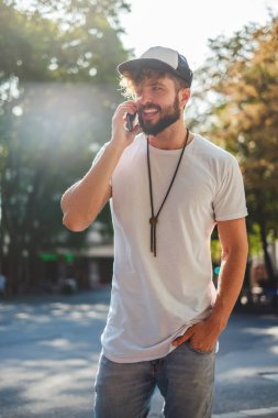 Kentsel adam telefonda konuşurken gülümseyen