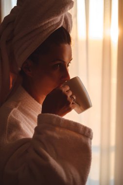 Pencerenin yanında kahve içme bornoz kadında 