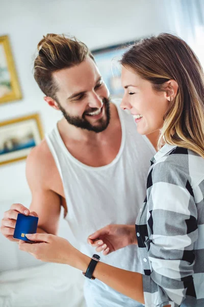 Casal segurando cartão de crédito e sorrindo — Fotografia de Stock