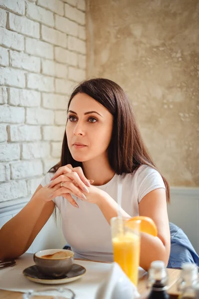 Girl with serious face looking across the table — Stock Photo, Image