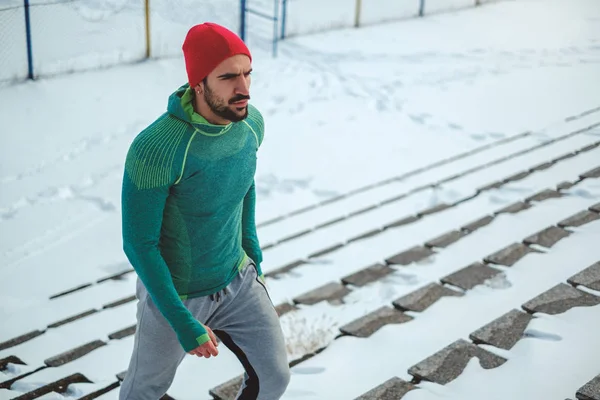 Esportista subindo as escadas no dia nevado — Fotografia de Stock