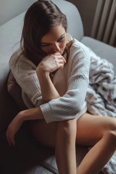 Sexig tjej med långa ben sitter på en soffa — Stockfoto