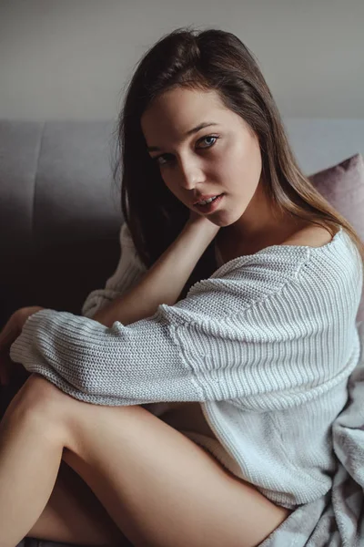 Porträtt av en sexig tjej som sitter på en soffa — Stockfoto