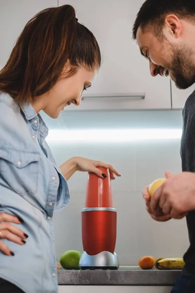 Couple laughing while blending smoothie in the kitchen — Stock Photo, Image