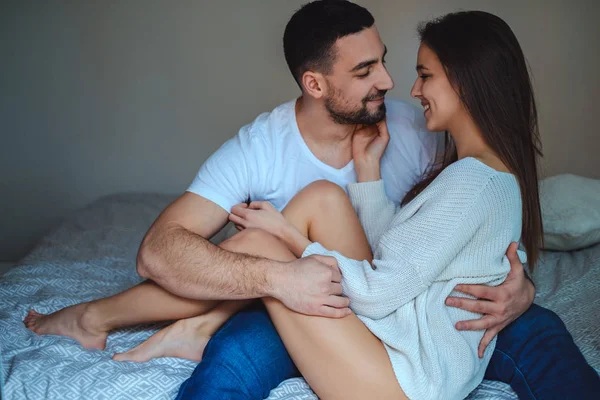 Erkek arkadaş kucağında oturan ve gülümseyen seksi kız