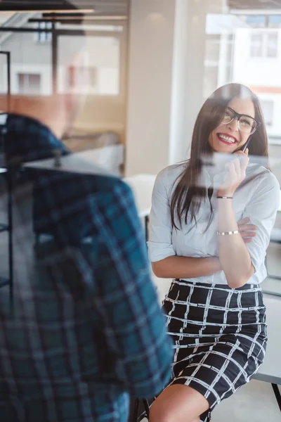 Donna che parla al telefono mentre un collega maschio è in attesa — Foto Stock