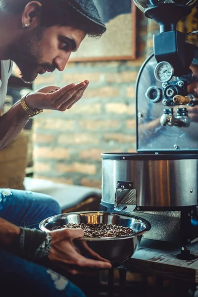 Man smelling coffee beans which he roasted — Stock Photo, Image