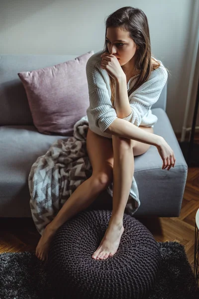 Szomorú szexi lány egyedül a kanapén ül — Stock Fotó