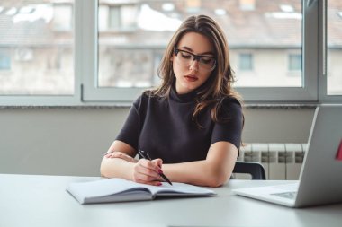 Ofiste defterini içinde kıvranmaya kadın