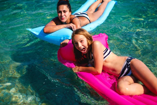 Mãe e filha se divertindo em camas flutuantes — Fotografia de Stock