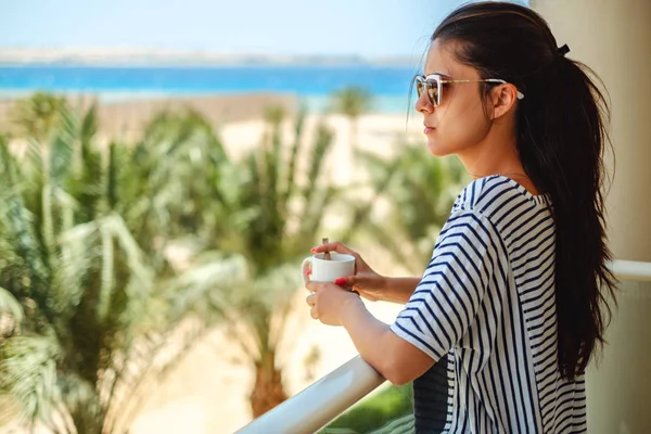 Chica disfrutando de una taza de café en un balcón —  Fotos de Stock