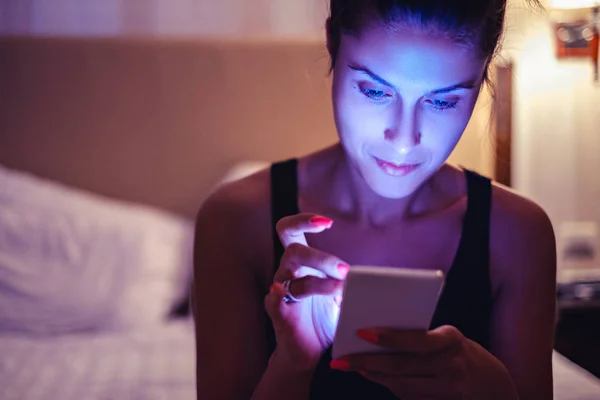 Kız Yatak odasında cep telefonu bakarak