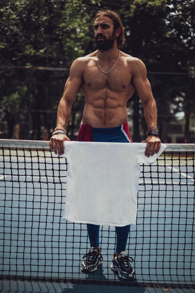 Hombre sin camisa de pie en la cancha de tenis ycamisa de celebración anfd — Foto de Stock