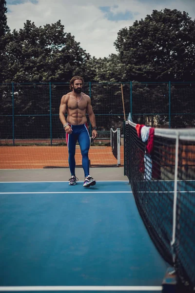 Homem sem camisa andando na quadra de tênis — Fotografia de Stock