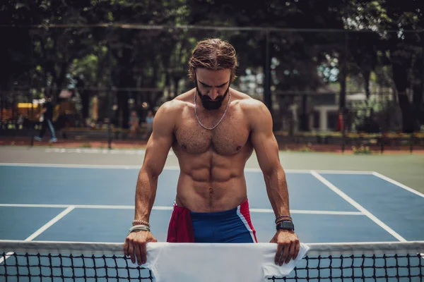 Barbudo hombre sin camisa de pie en la cancha de tenis —  Fotos de Stock