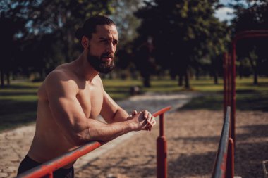 Hippi sporcu açık hava spor salonunda dinleniyor.