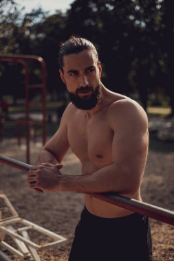 Sert adam açık hava spor salonunda dinleniyor.