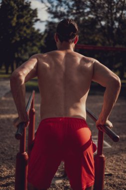 Sporcu, açık spor salonundaki parmaklıklara daldı.