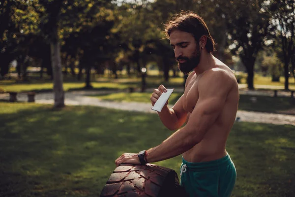 Hombre guapo comiendo barra de proteína después del entrenamiento duro —  Fotos de Stock