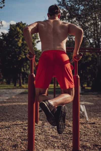 Hipster macht Dips an der Stange im Outdoor-Fitnessstudio — Stockfoto