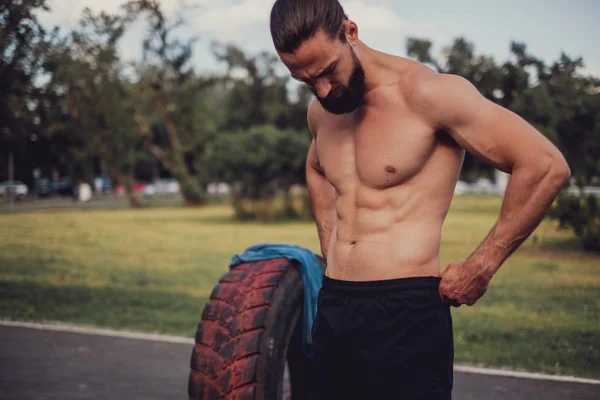 Bearded athlete stanfing by the workout tire — Stock Photo, Image